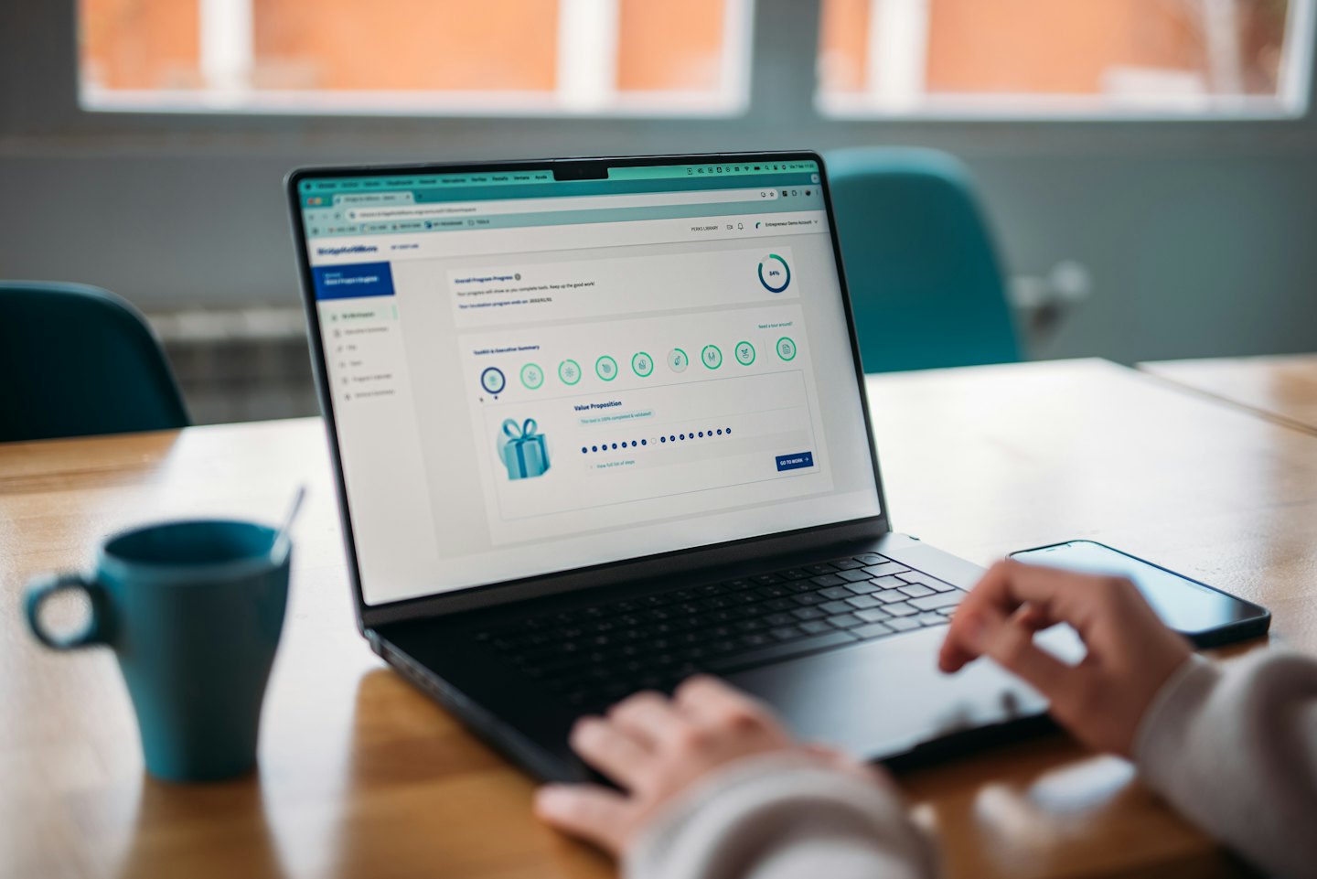 Hands typing on a laptop showing business software dashboard.