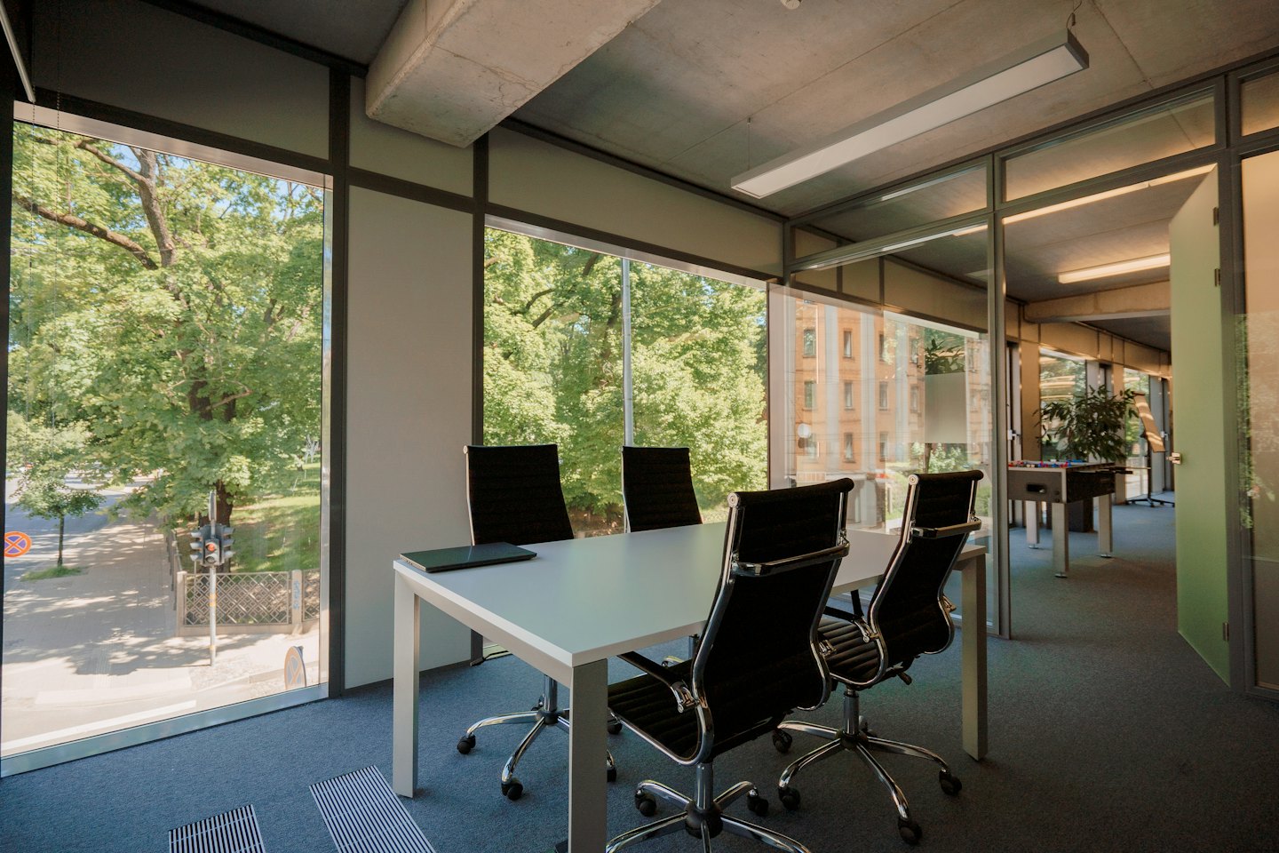 Modern meeting room with a large table and glass partitions.